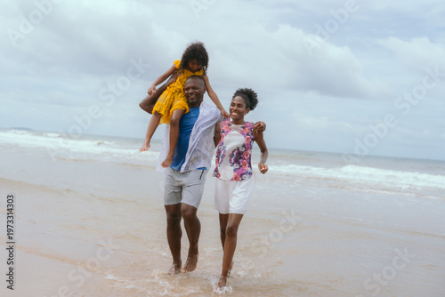 Foto Shot of a young couple and their kids spending the day at the beach