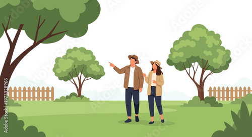 Couple walking in a park, pointing and discussing nature, surrounded by trees and a fence.