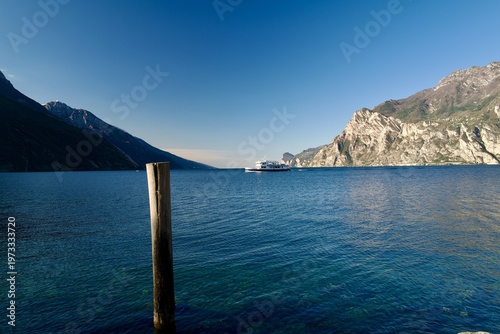Ferry crossing Lake Garda with clear blue water and mountain backdrop
