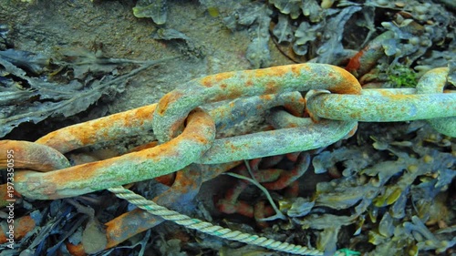 Rusty old anchor chain at the bottom of the ocean 