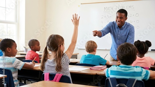 Enthusiastic African American teacher pointing at girl raising hand in diverse elementary classroom during interactive lesson promoting education engagement