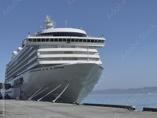 Modern cruiseship or cruise ship liner Serenity docked at terminal pier Piraeus Athens, Greece with harbor infrastructure and marine traffic panoramic city skyline view Mediterranean summer cruising