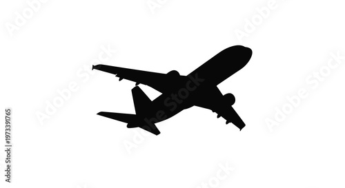 A sleek passenger airplane in flight captured as a dark silhouette