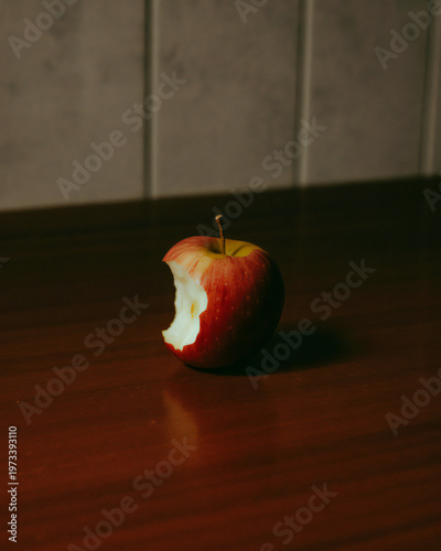 A bitten apple on a dark wooden surface still life photography