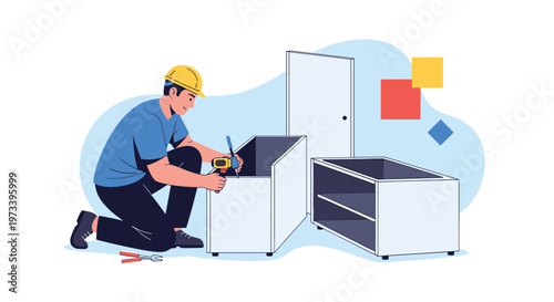 Male worker in blue t-shirt and yellow safety helmet assembling white modular furniture using electric screwdriver in bright room.