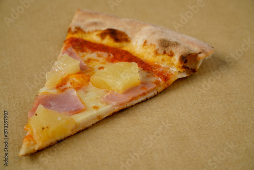 Hawaiian pizza in a box against a white background.