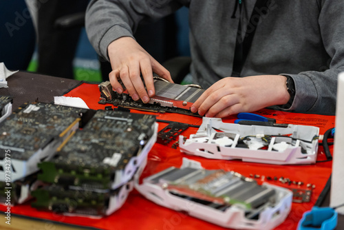 Canvas Print Caucasian person repairing and assembling graphics cards on a table