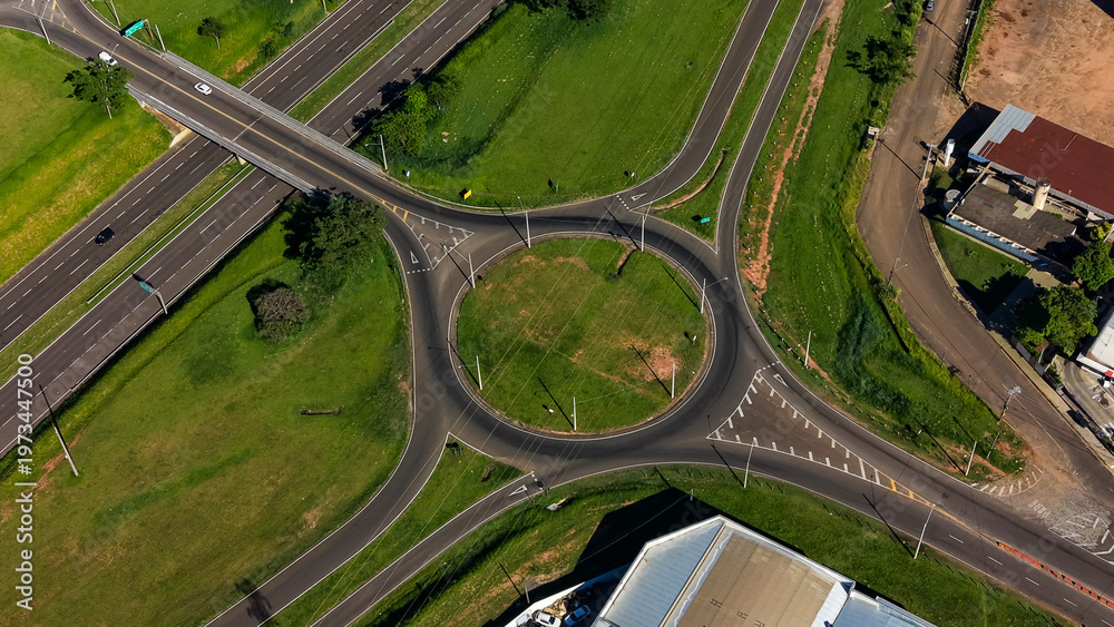 Fototapeta premium An aerial view of a roundabout with multiple roads and green spaces