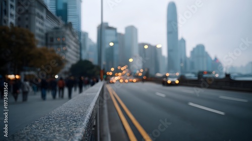 A hazy view down an elevated road toward a sprawling modern city skyline with pedestrians walking along the retaining wall