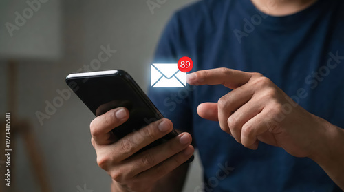 Closeup of a person holding a smartphone with a digital email notification icon showing 89 unread messages