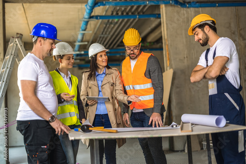 Female construction manager leading a site meeting with a diverse engineering team.