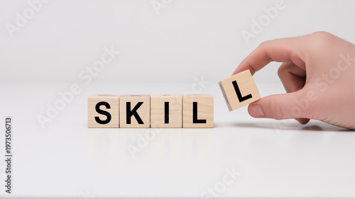 Wooden letters spelling skill with hand placing the last letter