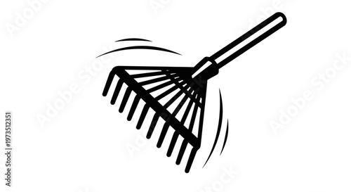 A black and silver rake with long tines being used to gather fallen leaves in a yard during autumn as part of outdoor seasonal cleanup efforts
