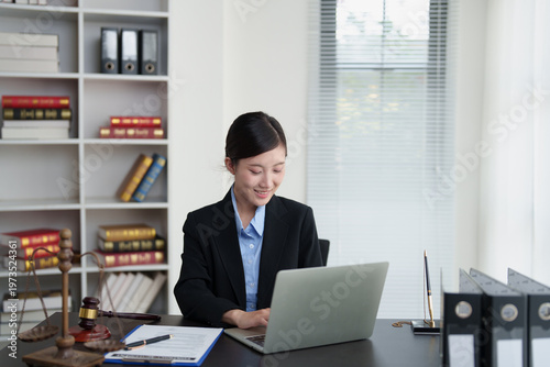 Tableau sur toile Female lawyer working on laptop at her office desk, specializing in legal servic