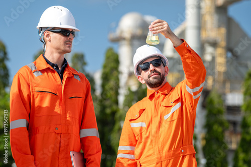фотографія Group of petroleum chemist with laptop and glass flask discussing oil sample quality test while analyzing octane and cetane values laboratory chemical testing at fuel refinery industrial site
