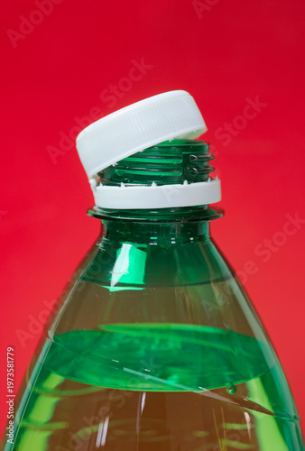 bottle cap connected to the neck of the bottle by solid tab attached to safety ring