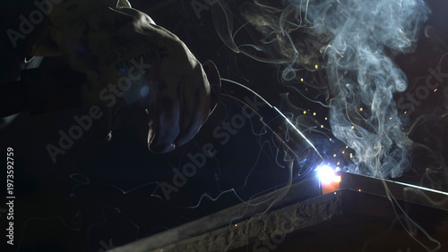 Tableau sur toile A person works on metal with a welding tool