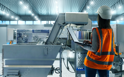 Obraz na płótnie Food production, engineer configures factory equipment using laptop, adjusting processing line and monitoring automated machinery in food manufacturing facility
