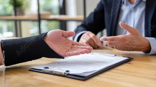 Person wearing a wrist brace extending hand during a discussion with a consultant about injury, disability, or insurance claim