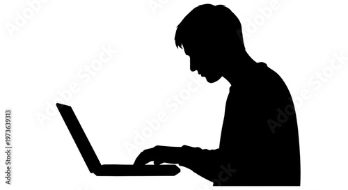 Silhouette of a person working intently on a laptop computer.