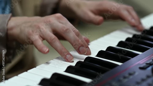 female pianist hands on black and white synthesizer keyboard, close-up view, young woman playing piano, professional musician