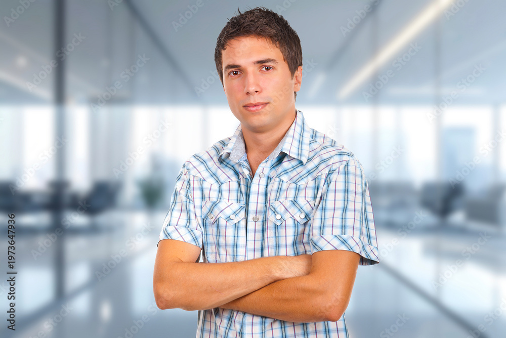 Obraz premium Young man stands confidently with crossed arms