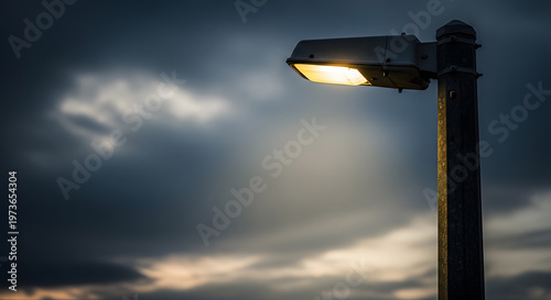 A solitary street light illuminates a dramatic cloudy night sky