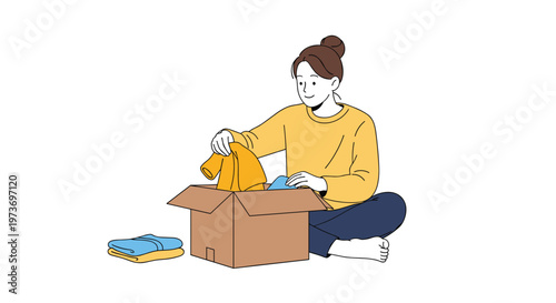 Young woman sitting on the floor while carefully packing her personal clothes into a cardboard box for a house move.