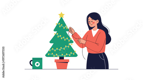 Happy woman decorating a small green Christmas tree with a string of lights to prepare for the festive winter holiday season at home.