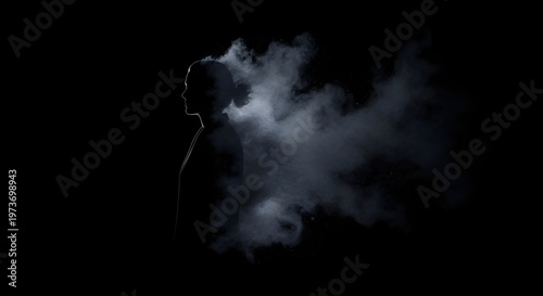 Silhouette of person dissolving into smoke against dark background
