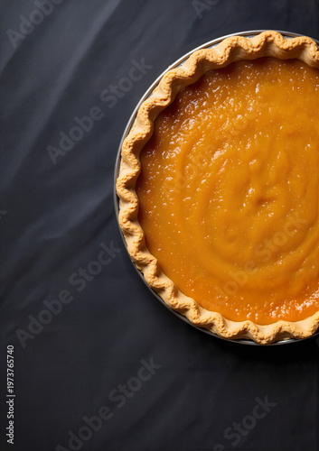 Pumpkin pie in a baked crust on black background for Thanksgiving  