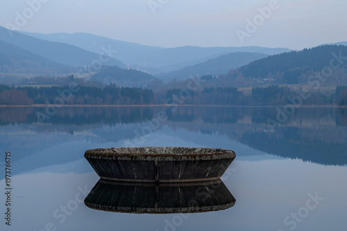 Nyrsko dam reservoir in cloudy spring dark evening with mountains