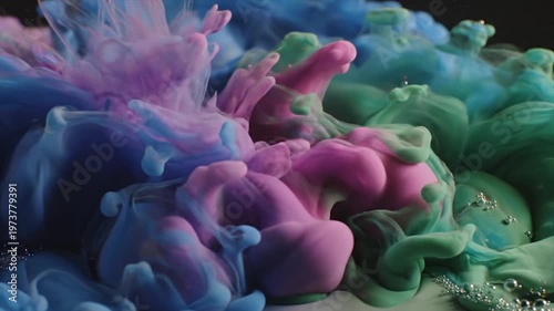 Vibrant crocheted flowers in blue, pink, and green on dark background