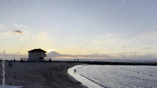 Haifa, Israel, April 3, 2026. View of Bat Galim beach at sunset with the silhouette of a lifeguard tower, the sea, and the breakwater.