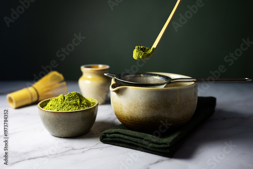 Close-up of a traditional bamboo spoon holding a heap of matcha green tea powder.