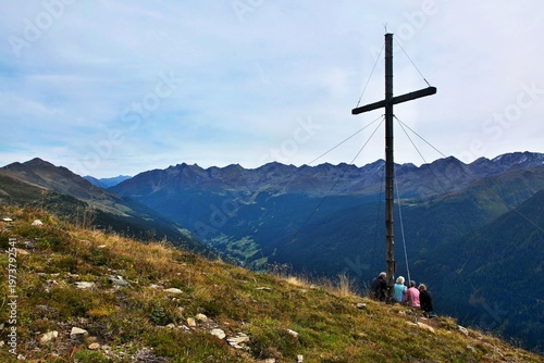 Austrian Alps - view of tourists at the cross on the  Hausberg mountain near Kappl