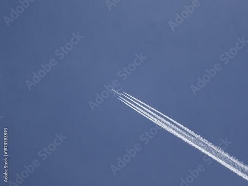 airplane in the blue sky leaving contrails