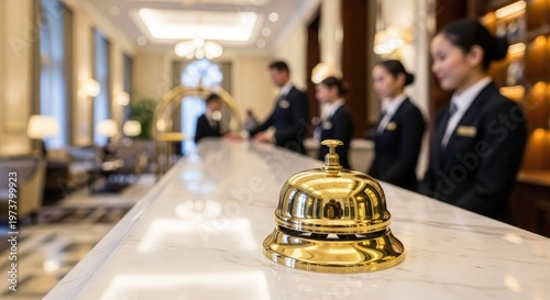 Hotel reception desk with service staff and golden bell indoor daytime