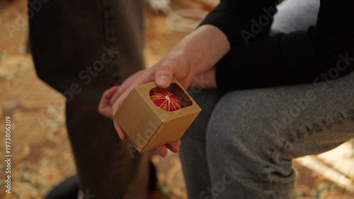 Close-up of hands painting a traditional Ukrainian Easter egg (Pysanka) with beeswax using a stylus (pysachok), preserving ancient folk traditions and symbols.