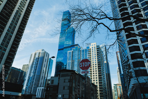 Εκτύπωση καμβά City buildings stand tall under a clear sky in an urban area with a stop sign vi