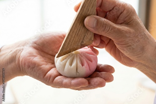 Confectioner using a triangular wooden tool to shape the petals of a delicate floral wagashi sweet