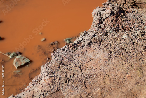Foto Rocky excavation slope above standing brown water, reflecting drainage problems,