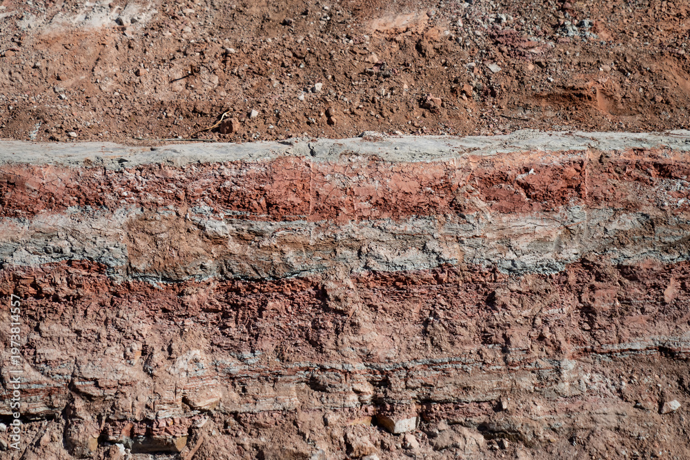 Fototapeta premium Exposed stratified soil wall in excavation cut, illustrating geological layers, ground analysis, and civil engineering site assessment needs