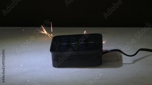 Solar charging device sparks due to malfunction creating fire risk and damage.