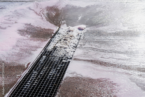 Quadro em tela Foamy wastewater flowing into linear trench drain on wet concrete surface, illus