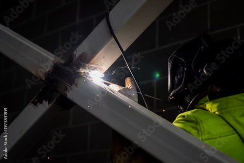 Bilde på lerret Protective helmet welder fusing metal frame joint on structural steel support, h