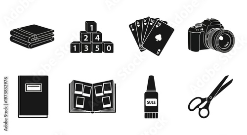 Collection of craft and hobby items including a camera, dice, playing cards, scrapbook, glue, scissors, and a stack of paper