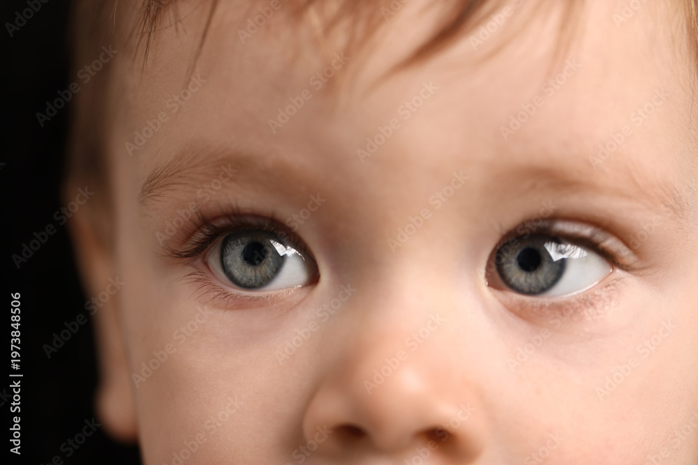 Naklejka premium Cute child with beautiful eyes on black background, closeup