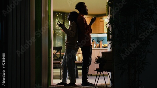 Tableau sur toile Back to back Black man and woman fighting in a dark hallway at home, relationship conflict and domestic life problems