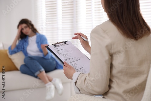Obraz na płótnie Professional psychologist with clipboard working with patient in office, selecti
